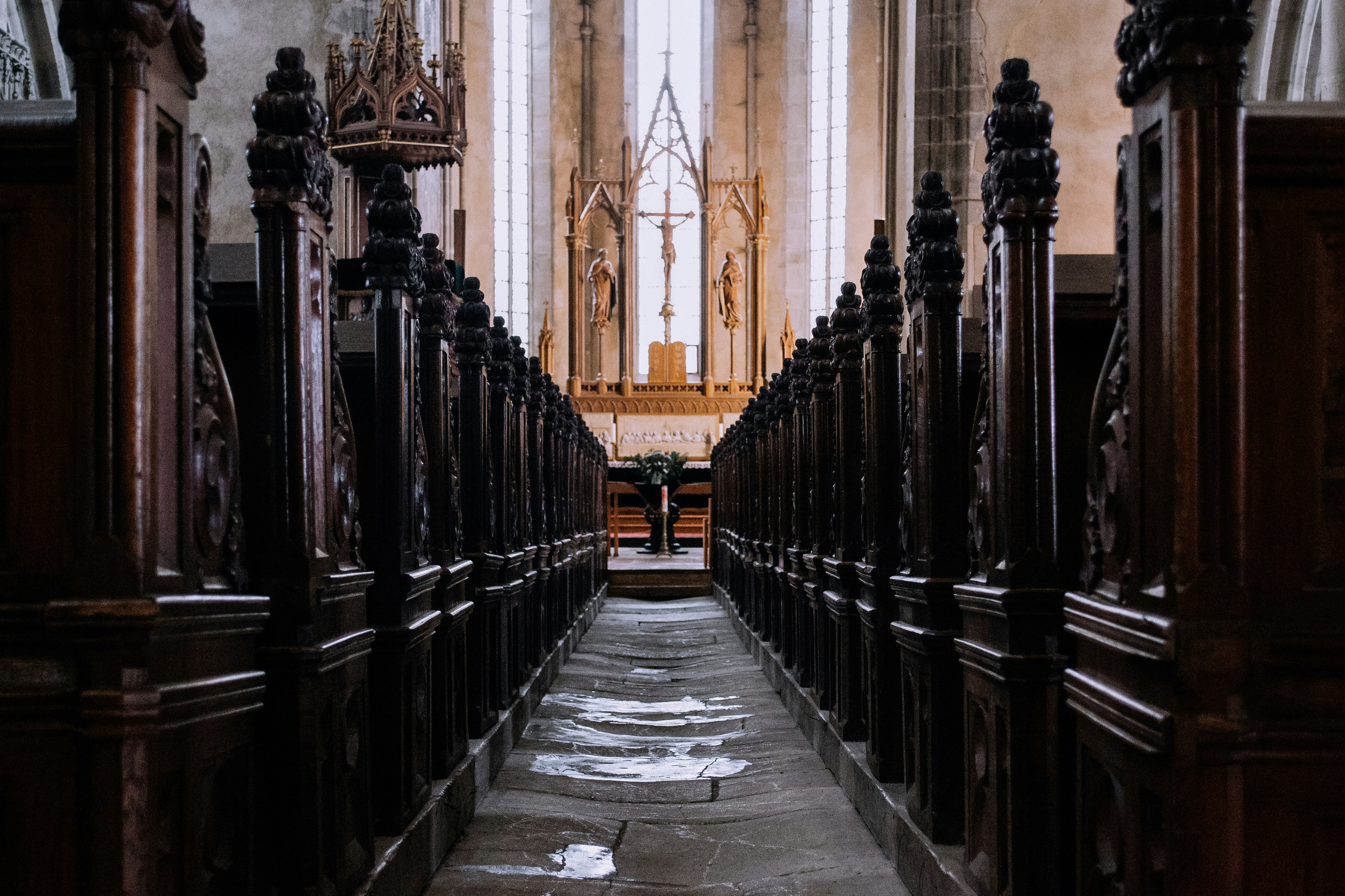 Looking down the aisle between the rows of seating in a church.